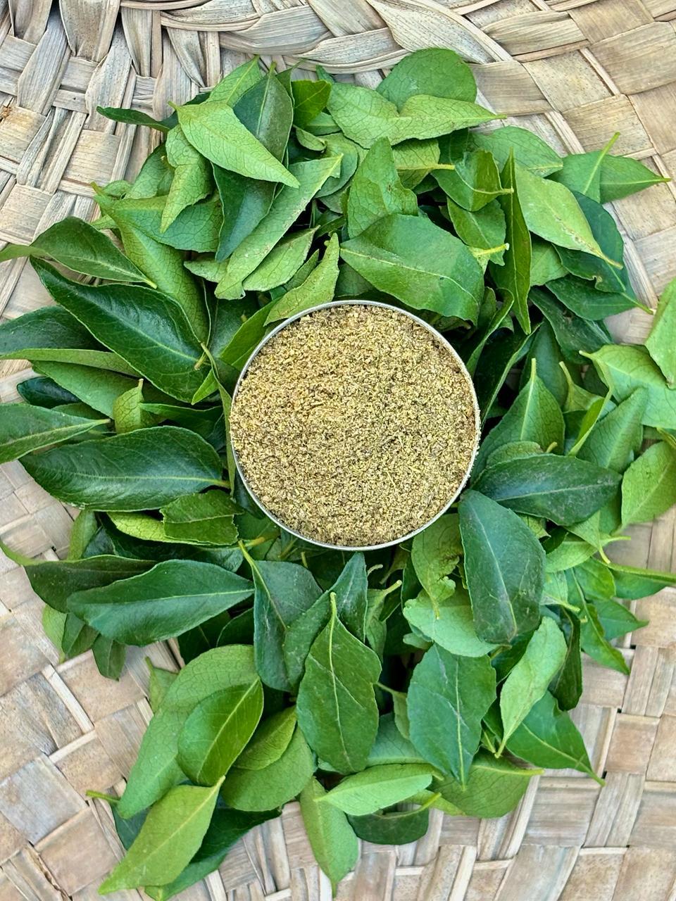 About Us Fresh curry leaves arranged around a brass bowl of Zest Right curry leaf powder