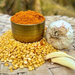 Home Freshly ground Zest Right masala in a brass bowl with garlic and split dal